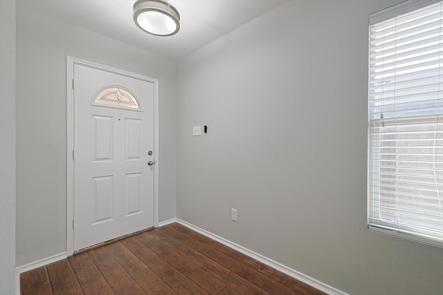 foyer featuring dark wood-type flooring and baseboards