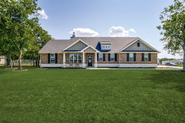 view of front of house with board and batten siding, fence, a shingled roof, and a front lawn