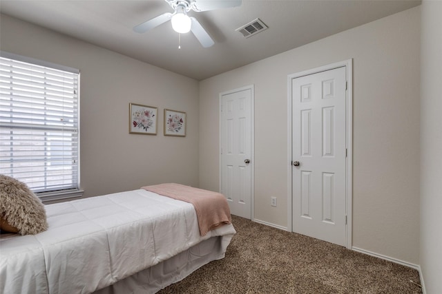 carpeted bedroom featuring visible vents and a ceiling fan