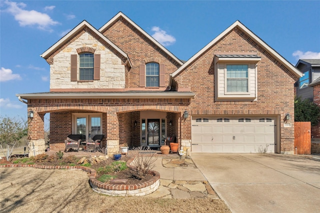 view of front of house featuring brick siding, covered porch, concrete driveway, an attached garage, and stone siding