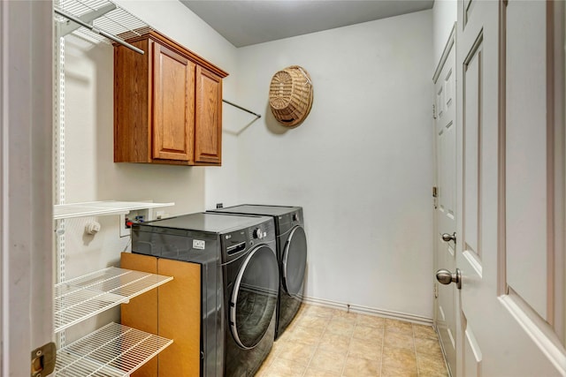 laundry area with separate washer and dryer, cabinet space, and baseboards