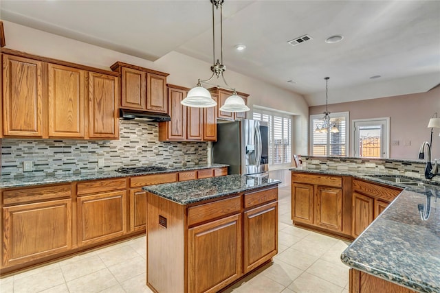 kitchen with visible vents, brown cabinets, stainless steel appliances, under cabinet range hood, and a sink