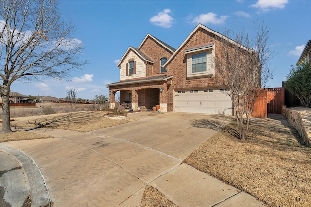 traditional home featuring a garage, concrete driveway, brick siding, and a porch