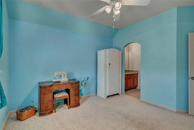 home office featuring ceiling fan, vaulted ceiling, baseboards, and light colored carpet