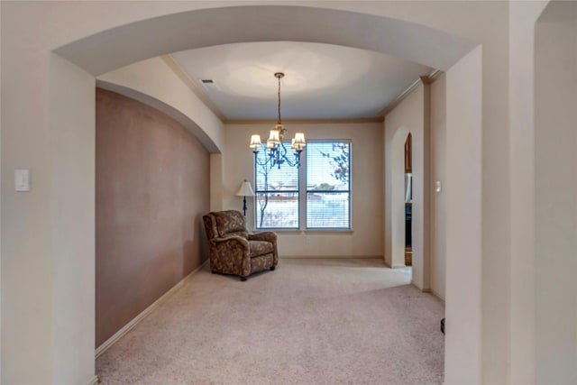 living area with baseboards, a notable chandelier, ornamental molding, and carpet flooring