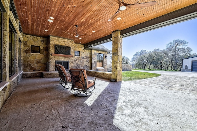 view of patio with ceiling fan and an outdoor stone fireplace