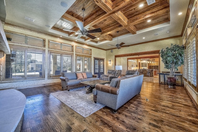 living area featuring visible vents, coffered ceiling, a towering ceiling, wood finished floors, and crown molding