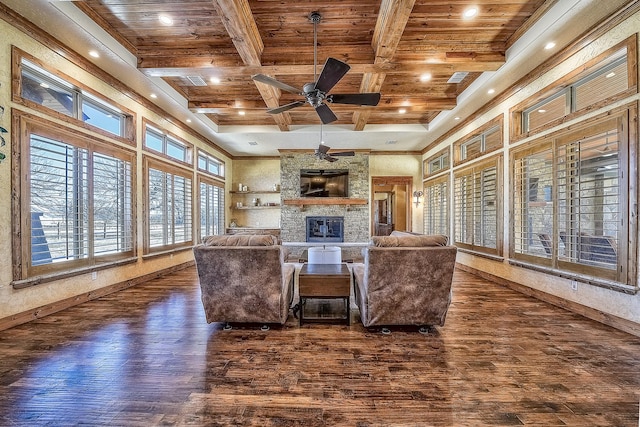 living area with a fireplace, wood ceiling, wood finished floors, beamed ceiling, and baseboards