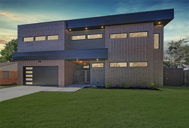 contemporary home with brick siding, fence, concrete driveway, a front yard, and an attached garage