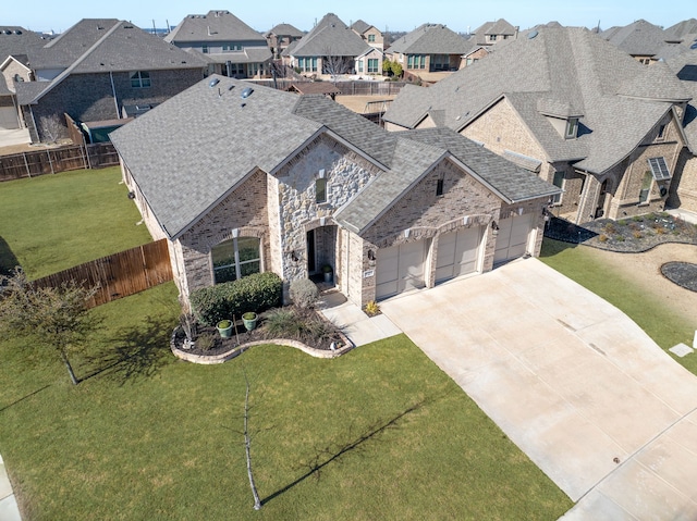 french country style house featuring an attached garage, a shingled roof, fence, concrete driveway, and a residential view