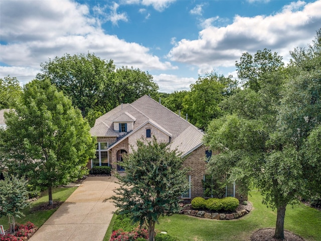 1313 Stoneoak Dr, Mckinney, TX 75072 - view of front facade featuring driveway, brick siding, and a front yard