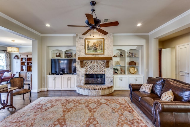 1313 Stoneoak Dr, Mckinney, TX 75072 - living area with wood finished floors, ornamental molding, a ceiling fan, a fireplace, and built in features
