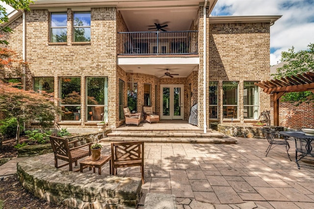 1313 Stoneoak Dr, Mckinney, TX 75072 - back of house with a balcony, ceiling fan, french doors, a pergola, and brick siding