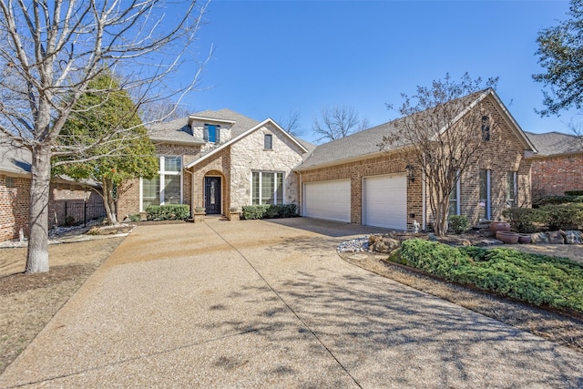 traditional-style home with a garage, brick siding, concrete driveway, and a shingled roof