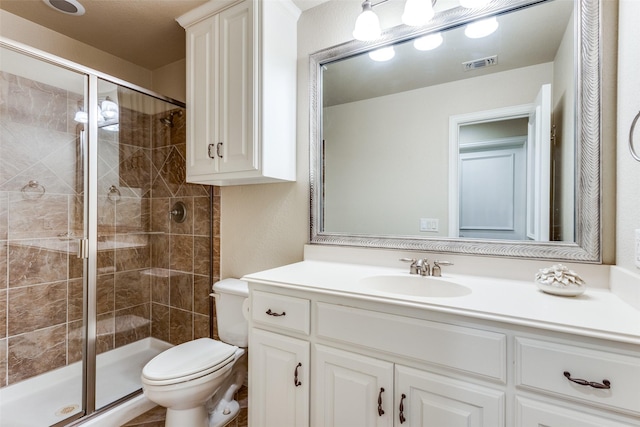 bathroom with toilet, a stall shower, vanity, and visible vents