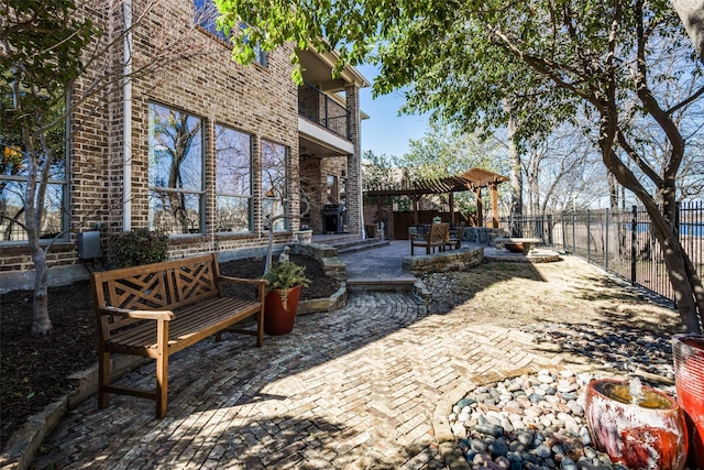 view of patio / terrace featuring fence and a balcony