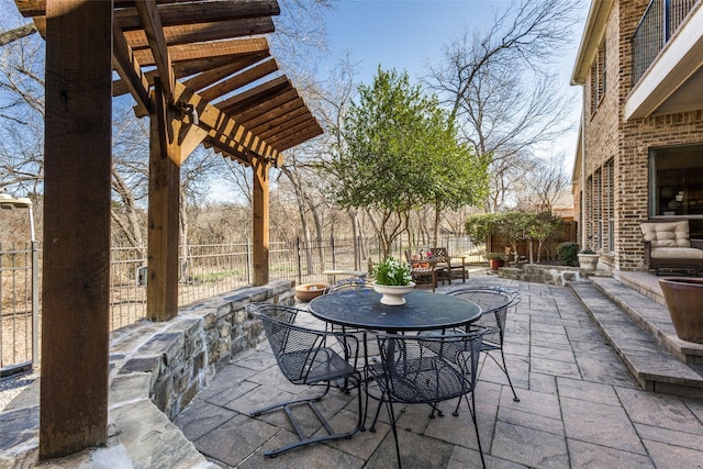 view of patio featuring outdoor dining area, a fenced backyard, and a pergola