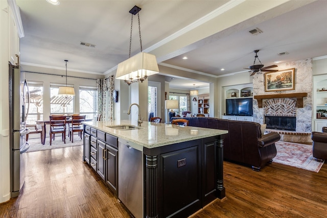 1313 Stoneoak Dr, Mckinney, TX 75072 - kitchen featuring a sink, open floor plan, a stone fireplace, dark wood-type flooring, and ornamental molding