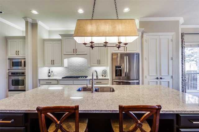 kitchen with a breakfast bar area, ornamental molding, a sink, stainless steel appliances, and backsplash