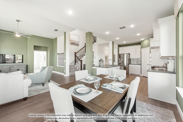 dining area featuring stairway, wood finished floors, and visible vents