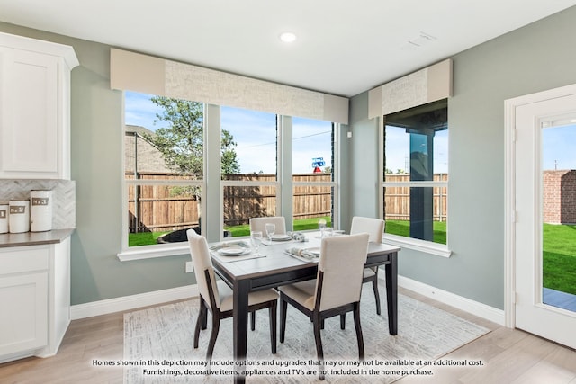 dining area with a healthy amount of sunlight, light wood finished floors, and baseboards