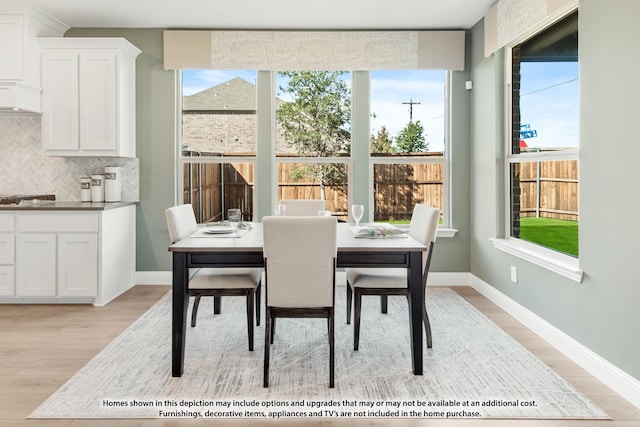 dining area featuring light wood finished floors and baseboards