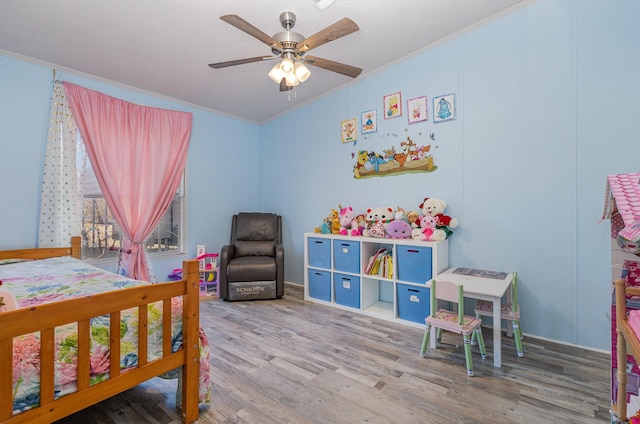 bedroom with a ceiling fan, crown molding, and wood finished floors