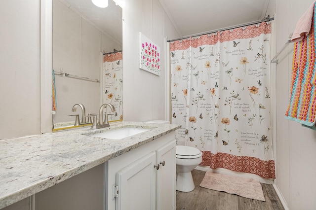 full bath featuring toilet, a shower with shower curtain, wood finished floors, vanity, and ornamental molding