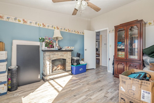 living area featuring crown molding, a fireplace, and wood finished floors