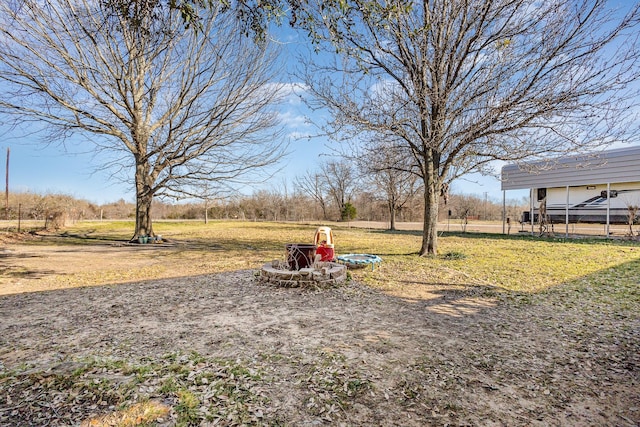 view of yard with a fire pit and a detached carport