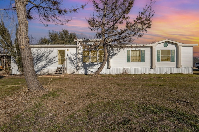 view of property exterior featuring entry steps and a lawn