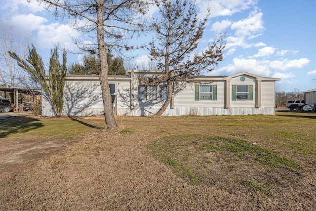 manufactured / mobile home with a front lawn and a carport