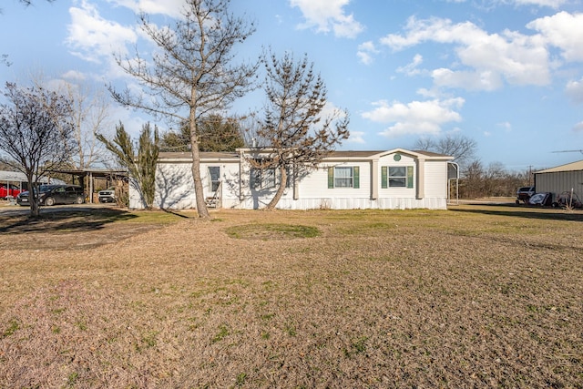 manufactured / mobile home featuring a carport and a front yard