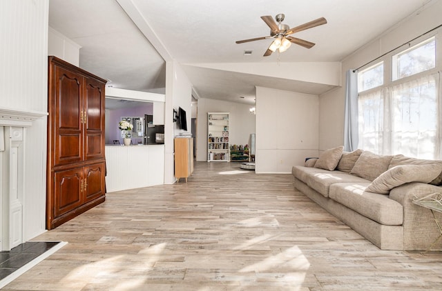 living area with lofted ceiling, light wood-style floors, ceiling fan, and visible vents