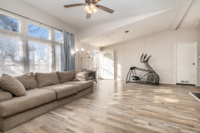 living area featuring a healthy amount of sunlight, visible vents, and wood finished floors