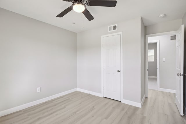 unfurnished bedroom featuring a ceiling fan, baseboards, visible vents, and light wood finished floors