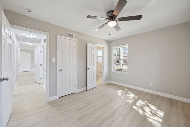 unfurnished bedroom featuring light wood-style floors, visible vents, baseboards, and a ceiling fan