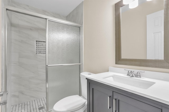 full bathroom with vanity, a shower stall, and toilet