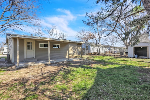 rear view of house featuring a patio, a lawn, a storage shed, fence, and an outdoor structure