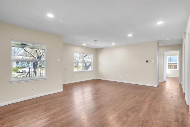 spare room featuring baseboards, wood finished floors, and recessed lighting