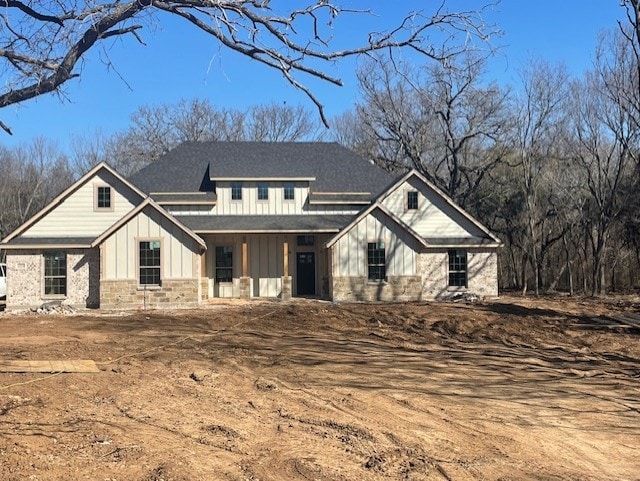 modern farmhouse style home with stone siding and board and batten siding