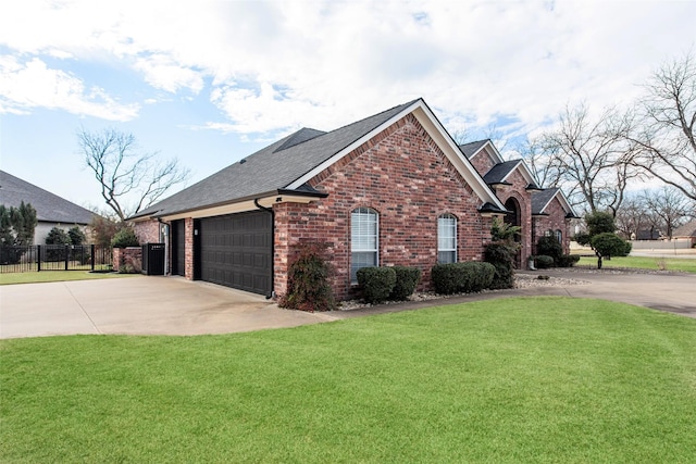 view of side of property with driveway, brick siding, a lawn, and fence