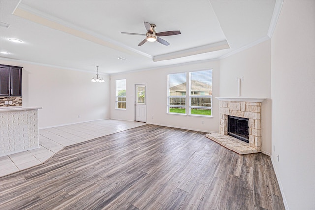 2305 Simmental Rd, Fort Worth, TX 76131 - unfurnished living room with a raised ceiling, crown molding, a ceiling fan, light wood finished floors, and a fireplace
