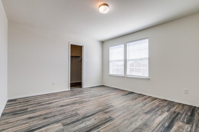 2305 Simmental Rd, Fort Worth, TX 76131 - unfurnished bedroom with wood finished floors, baseboards, a closet, and a spacious closet