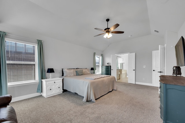 bedroom featuring lofted ceiling, light colored carpet, visible vents, ensuite bathroom, and baseboards