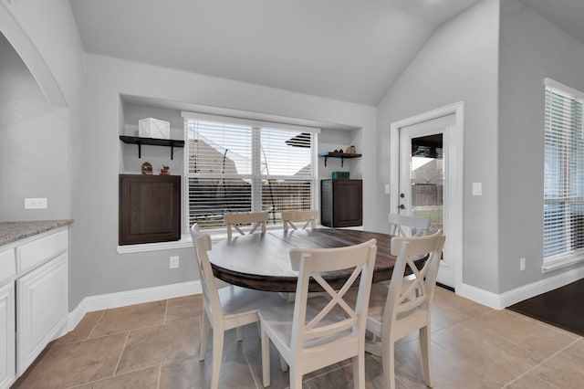 dining space featuring lofted ceiling and baseboards