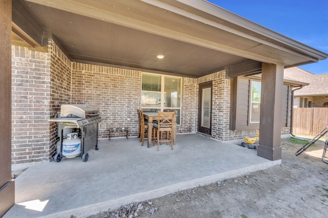 view of patio / terrace with outdoor dining space, a grill, and fence