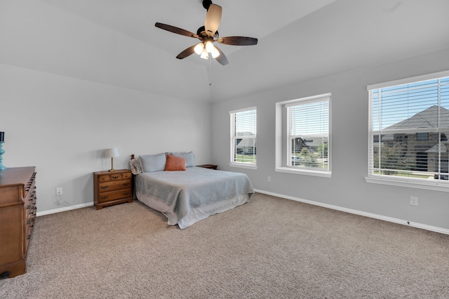 bedroom featuring a ceiling fan, light colored carpet, vaulted ceiling, and baseboards