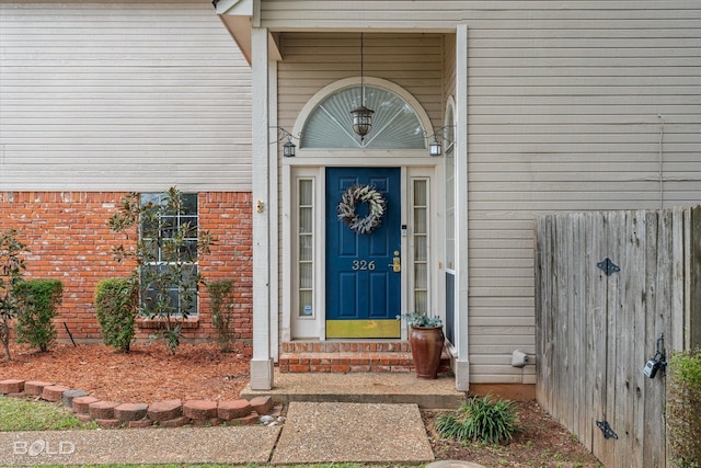 view of exterior entry featuring brick siding