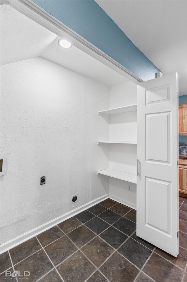 laundry room featuring stone finish flooring, baseboards, and electric dryer hookup